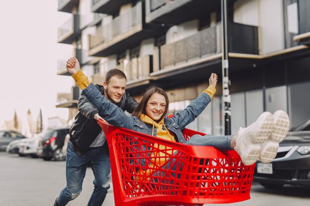 Linda familia jugando con un carrito de compras en una ciudad
