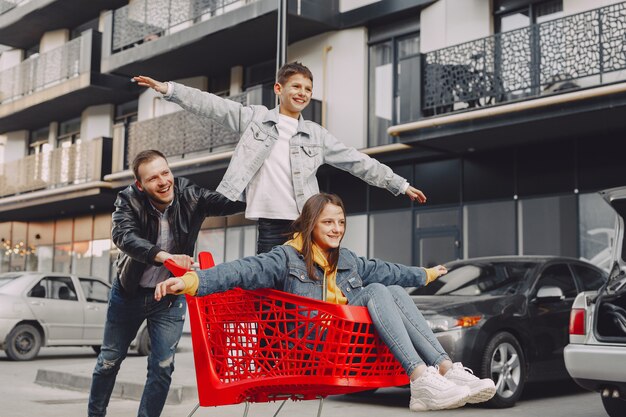 Linda familia jugando con un carrito de compras en una ciudad