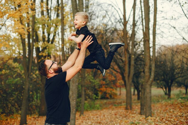 Linda familia jugando en un parque de otoño