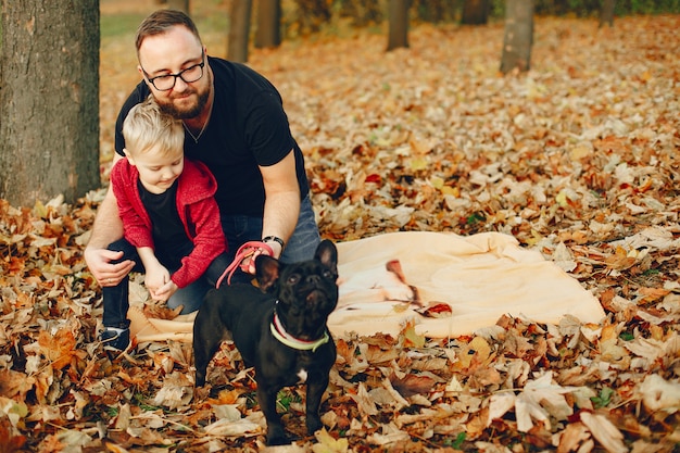 Linda familia jugando en un parque de otoño