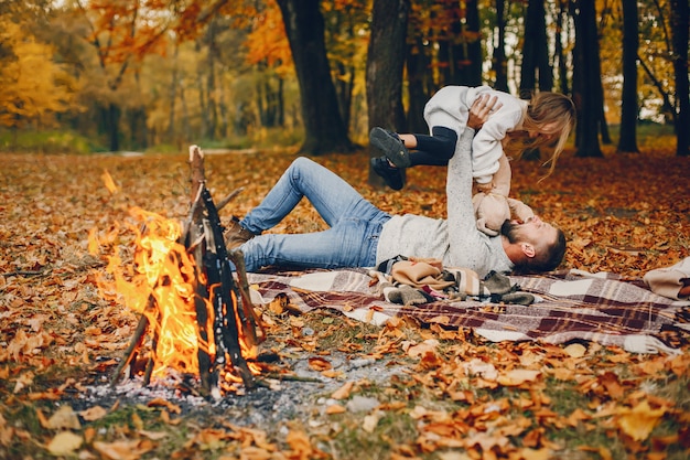 Linda familia jugando en un parque de otoño