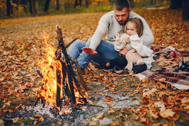 Linda familia jugando en un parque de otoño