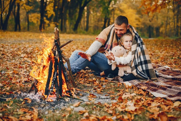 Linda familia jugando en un parque de otoño