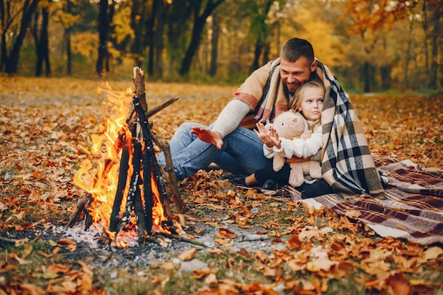 Linda familia jugando en un parque de otoño