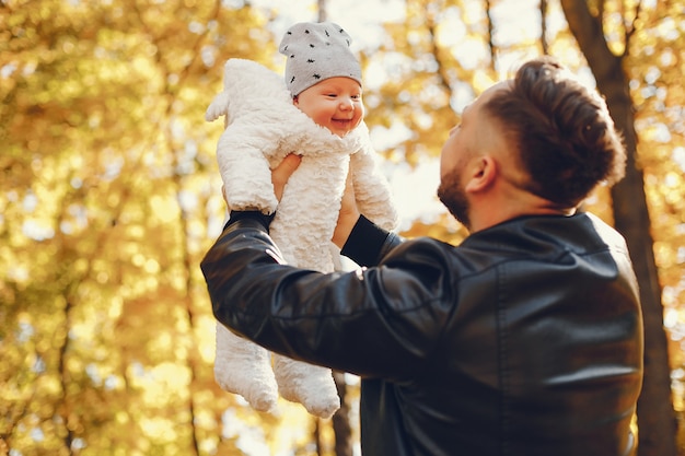 Linda familia jugando en un parque de otoño