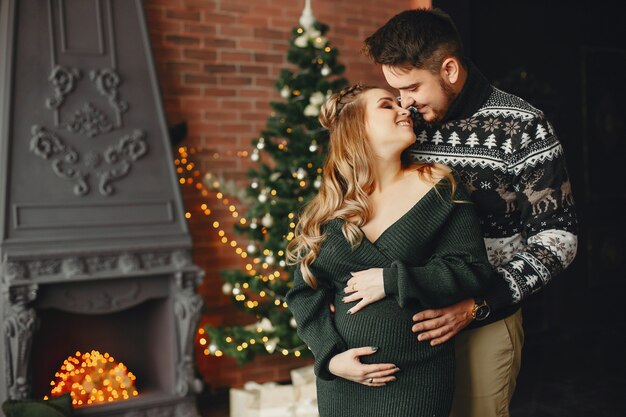 Linda familia de pie cerca del árbol de navidad