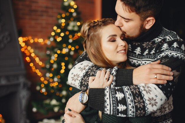 Linda familia de pie cerca del árbol de navidad