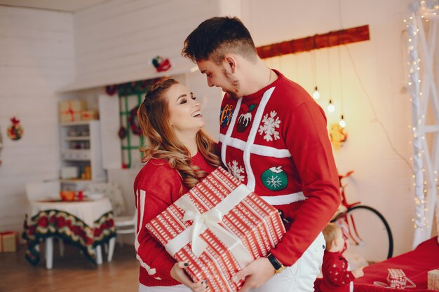 Linda familia de pie cerca del árbol de navidad