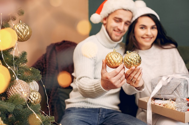 Linda familia sentada en casa cerca del árbol de navidad