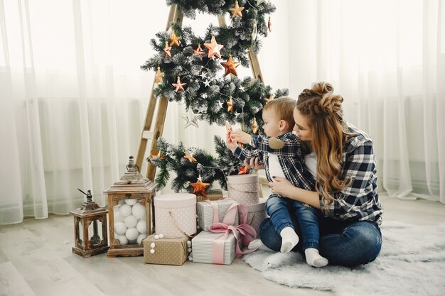 Linda familia sentada cerca del árbol de navidad