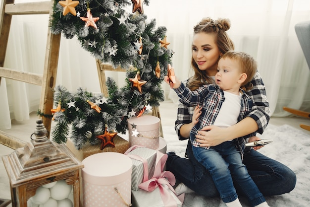 Linda familia sentada cerca del árbol de navidad