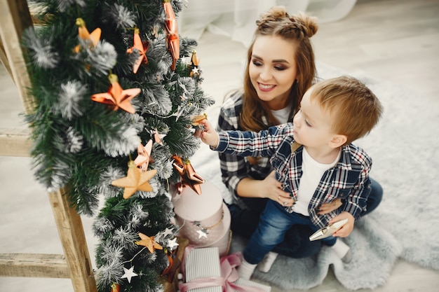 Linda familia sentada cerca del árbol de navidad