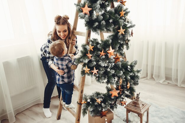 Linda familia sentada cerca del árbol de navidad