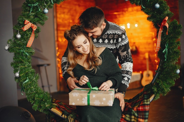 Linda familia sentada cerca del árbol de navidad