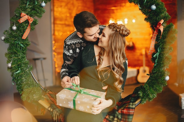 Linda familia sentada cerca del árbol de navidad