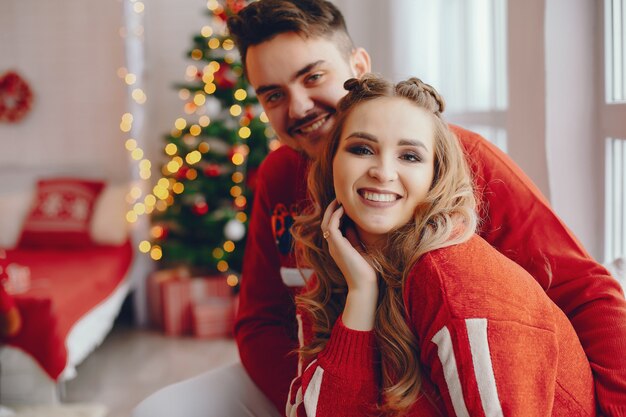 Linda familia sentada cerca del árbol de navidad