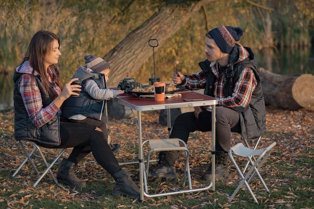 Linda familia sentada en un picnic en un bosque