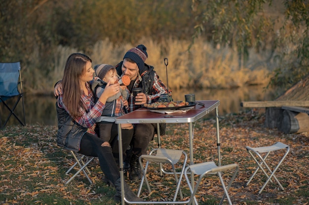 Linda familia sentada en un picnic en un bosque