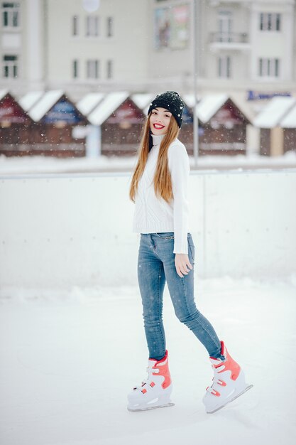 Linda y hermosa chica en un suéter blanco en una ciudad de invierno