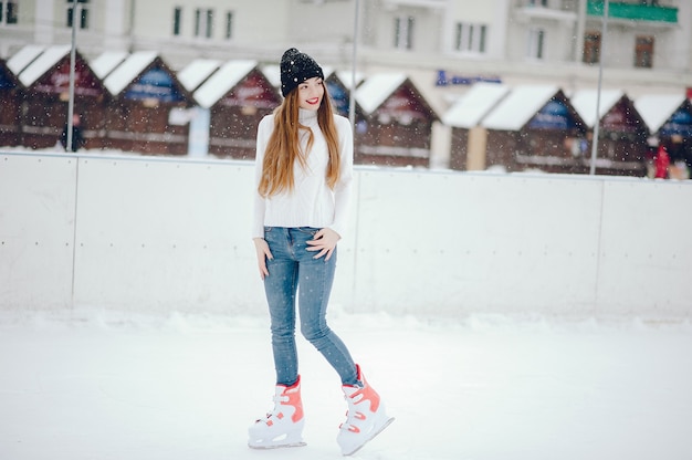 Linda y hermosa chica en un suéter blanco en una ciudad de invierno