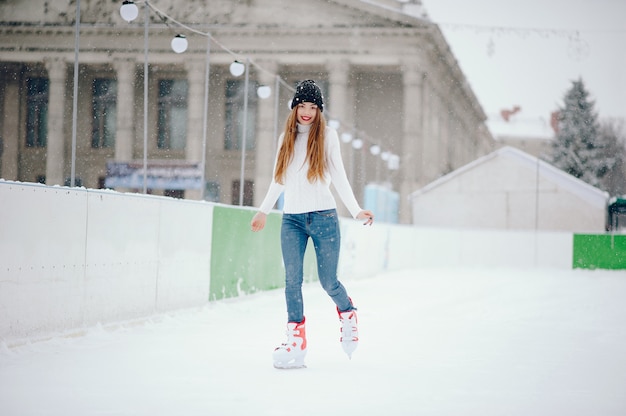 Linda y hermosa chica en un suéter blanco en una ciudad de invierno