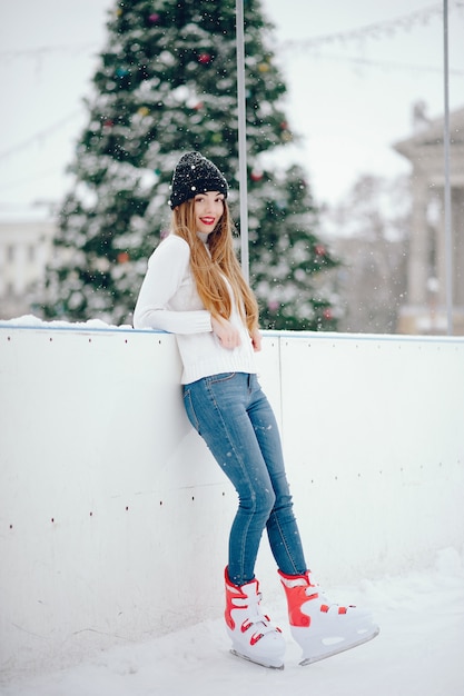 Linda y hermosa chica en un suéter blanco en una ciudad de invierno