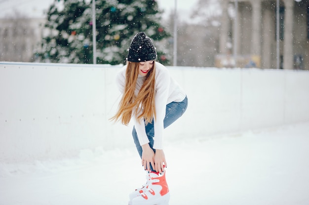 Linda y hermosa chica en un suéter blanco en una ciudad de invierno