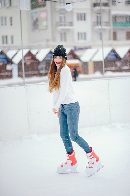 Linda y hermosa chica en un suéter blanco en una ciudad de invierno