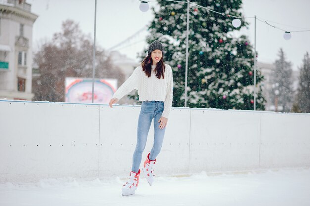 Linda y hermosa chica en un suéter blanco en una ciudad de invierno