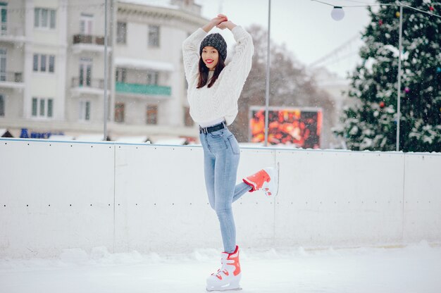 Linda y hermosa chica en un suéter blanco en una ciudad de invierno