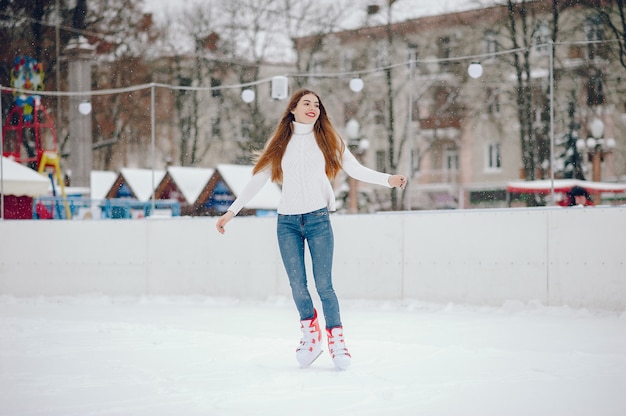 Linda y hermosa chica en un suéter blanco en una ciudad de invierno