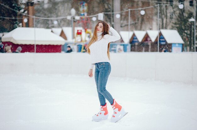 Linda y hermosa chica en un suéter blanco en una ciudad de invierno