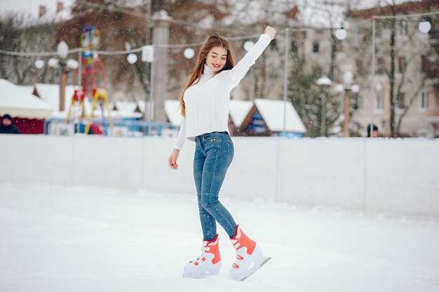 Linda y hermosa chica en un suéter blanco en una ciudad de invierno