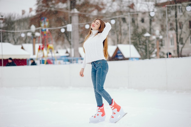 Linda y hermosa chica en un suéter blanco en una ciudad de invierno