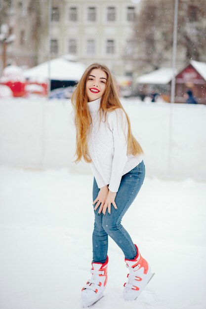 Linda y hermosa chica en un suéter blanco en una ciudad de invierno