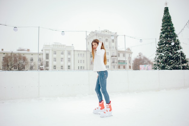 Linda y hermosa chica en un suéter blanco en una ciudad de invierno