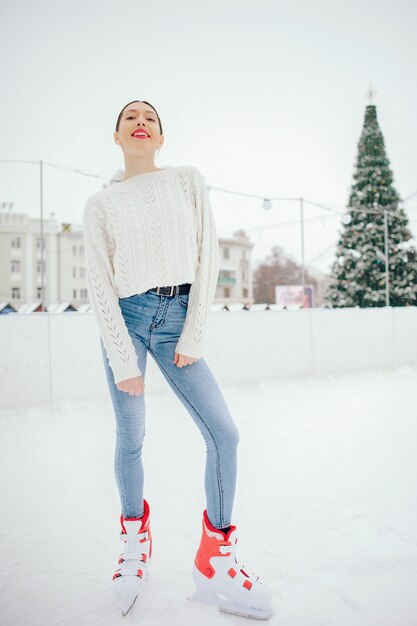 Linda y hermosa chica en un suéter blanco en una ciudad de invierno