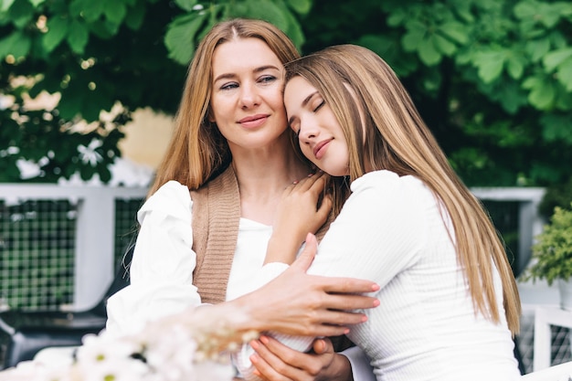 Linda hija joven abrazando a su madre con amor.