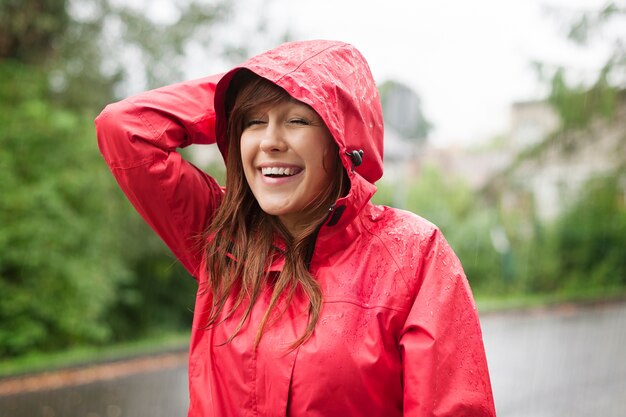 Linda joven caminando bajo la lluvia