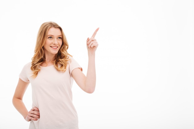 Linda jovencita sonriente señalando.