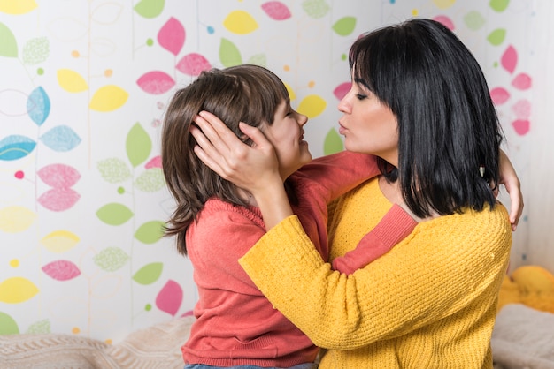 Linda madre e hija abrazándose y besándose