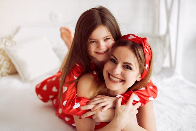 Linda madre e hija en casa en pijama