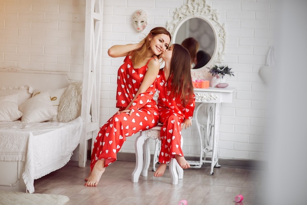 Linda madre e hija en casa en pijama