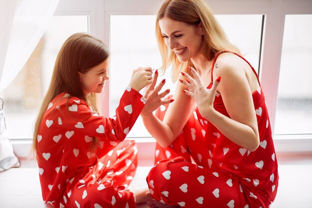 Linda madre e hija en casa en pijama