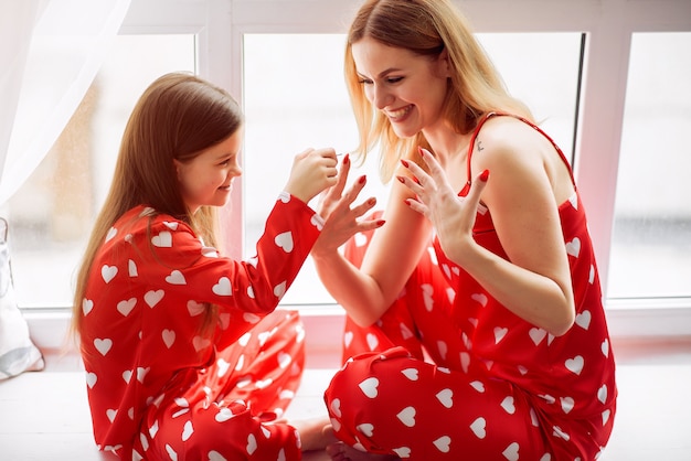 Linda madre e hija en casa en pijama