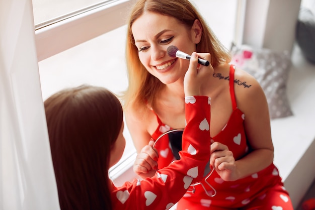 Linda madre e hija en casa en pijama