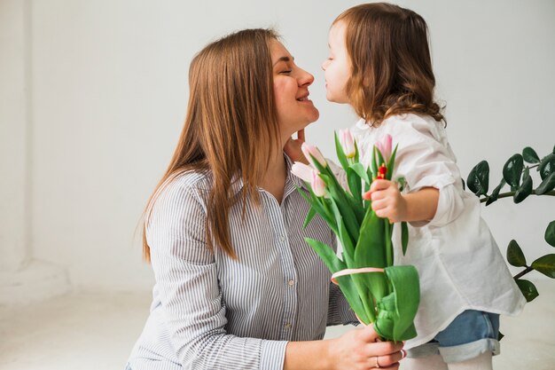 Linda madre e hija con flores de tulipán