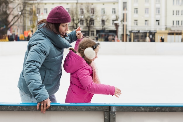 Foto gratuita linda madre y niña patinaje sobre hielo