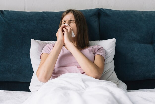 Linda mujer acostada en cama sufriendo de frío