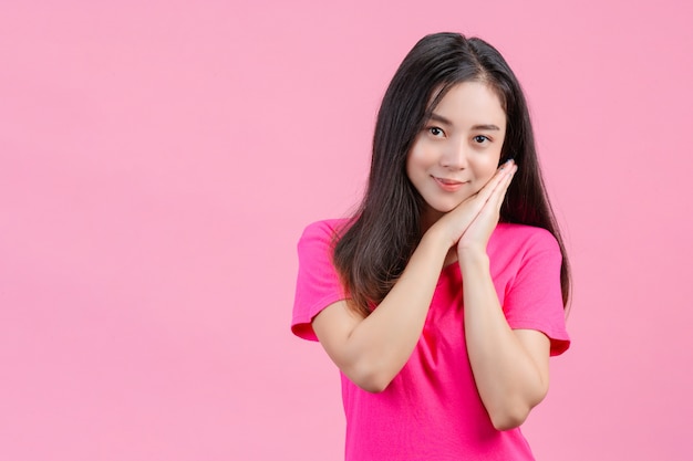 Linda mujer asiática blanca plantea tímido en un rosa.